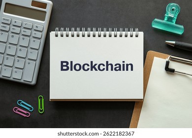 There is notebook with the word Blockchain. It is as an eye-catching image.