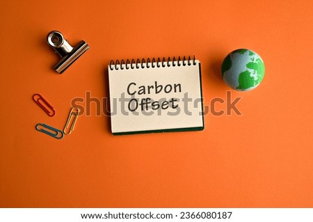 There is notebook with the word Carbon Offset. It is as an eye-catching image.