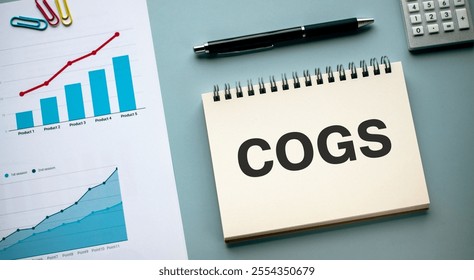 There is notebook with the word COGS. It is an abbreviation for Cost of goods sold as eye-catching image. - Powered by Shutterstock