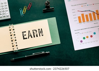 There is notebook with the word EARN. It is as an eye-catching image.