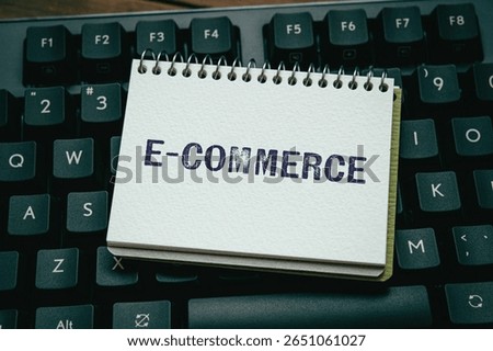 There is notebook with the word e-Commerce. It is as an eye-catching image.