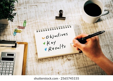 There is notebook with the word Objectives Key Results. It is as an eye-catching image.