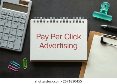 There is notebook with the word Pay Per Click Advertising. It is as an eye-catching image.