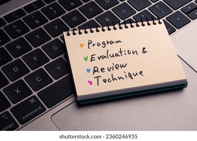 There is notebook with the word Program Evaluation and Review Technique. It is as an eye-catching image.
