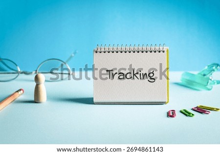 There is notebook with the word Tracking. It is as an eye-catching image.