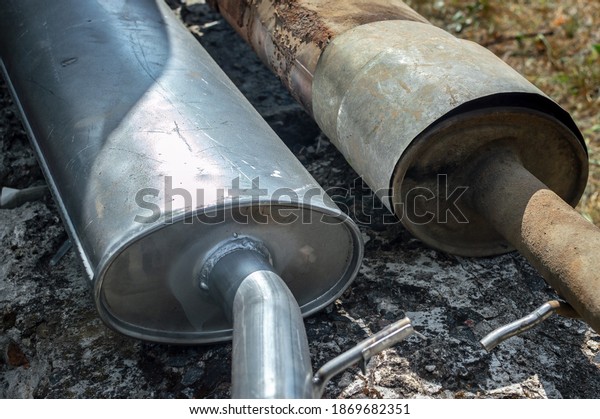There are\
old and new exhaust pipes nearby. Repair, replacement of the\
exhaust system in used cars. Selective\
focus.