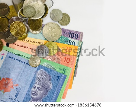 There are one,five, ten, twenty, fifty, hundred ringgit malaysia (MYR) and coins on white background. /Malaysia Currency (MYR): Stack of Ringgit Malaysia bank note and coins.