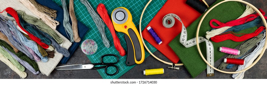 There Are Quilting, Embroidery And Sewing Tools On The Table. Patchwork Knife, Scissors, Lined Cutting Mat, Self-locking, Threads, Measuring Tape, Sewing Floss, Hoop. Banner