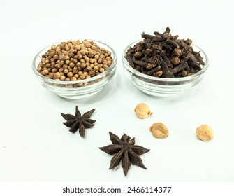 there are several kitchen spices (coriander seeds, star anise, clove, cardamom nut) on a white background.  - Powered by Shutterstock