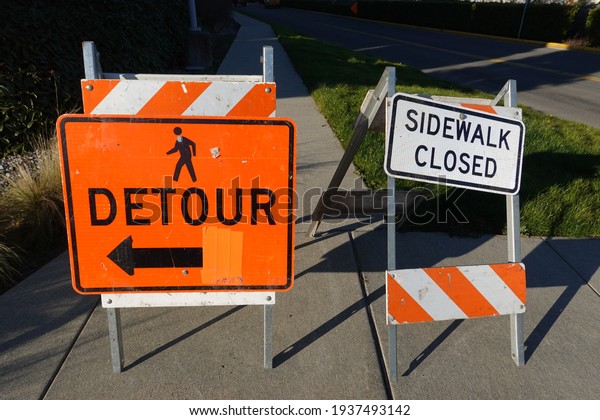 There are sidewalk closure signs posted along the\
pedestrian edge of the\
road.