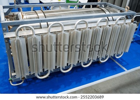 There is a sizable metal object that is currently positioned on top of a bluecolored table, creating an interesting contrast in this space and drawing attention to both the object and the table