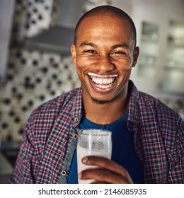 Is There Something On My Face. Cropped Portrait Of A Handsome Young Man Drinking A Glass Of Milk In The Kitchen At Home.