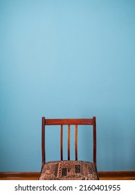 There Is A Soviet Retro Chair Against The Blue Wall. Design And Wallpaper. Place For Text. Copy Space. Wall Texture. Abstraction. Background. Vertical