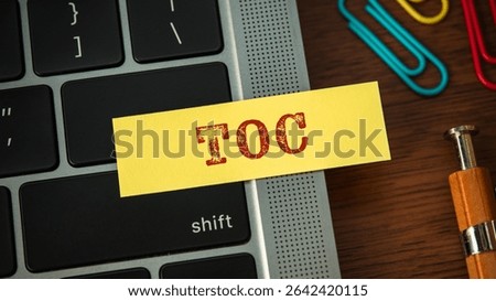 There is sticky note with the word TOC. It is an abbreviation for Theory Of Constraints as eye-catching image.