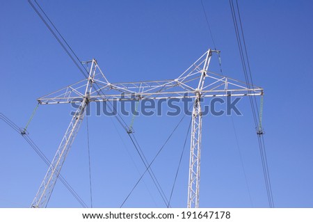 There is tangent tower with electric lines on blue sky background in Russia