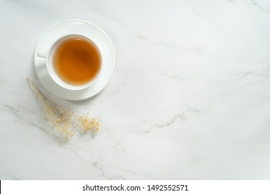 There Is Tea In White Glass On The Marble Table, As Seen From The Top Corner.