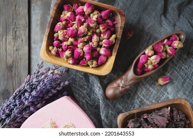 there is a teaspoon of rosebud tea on the wooden table. Tea time, cozy atmosphere. Kitchen still life in Chinese style with pink floral tea on a background of contrasting morning light. Top view