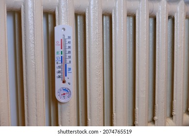There is a thermometer in the radiator, it shows a temperature of 14 degrees Celsius or 57 Fahrenheit. The heating radiator is cold. Problems of heating houses in winter.