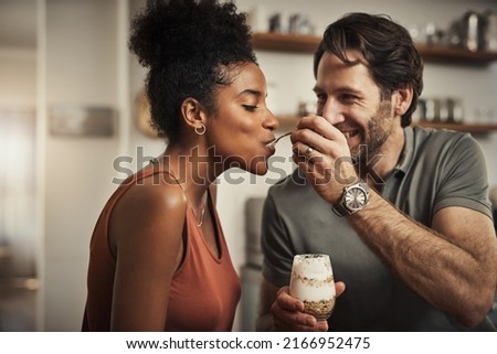 And there we go. Cropped shot of an affectionate middle aged man feeding his wife dessert in their kitchen at home.