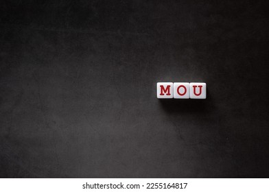 There is white cube with the word MOU. It is an abbreviation for Memorandum of Understanding as eye-catching image. - Shutterstock ID 2255164817