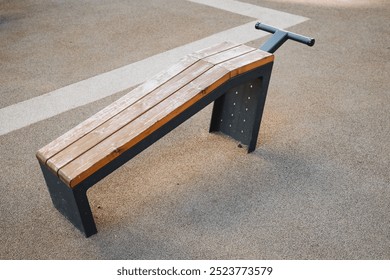 There is a wooden bench that features a sturdy metal frame resting on the ground surface, making it a perfect piece of outdoor furniture for relaxation and enjoyment in various environments - Powered by Shutterstock