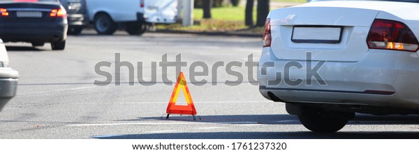 There is yellow triangle accident sign on road.\
Turn on emergency light and set emergency parking sign. Call\
insurance commissioner and paperwork. Attraction lawyer. Make\
diagram an accident
