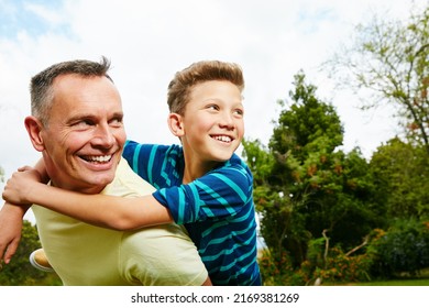 Theres Always Time For A Piggyback. Shot Of A Dad Giving His Son A Piggyback Outside.