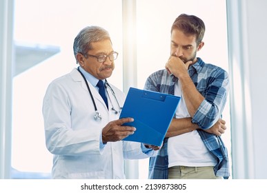 Theres a few things you have to focus on here. Shot of a confident mature male doctor showing test results to a patient inside of a hospital during the day. - Powered by Shutterstock
