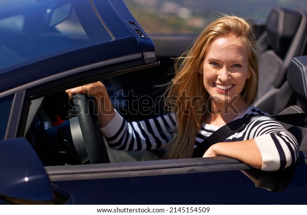 Theres no one in the passenger set yet. Shot\
of a young woman driving in a sports\
car.