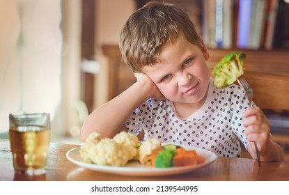 Theres No Way Im Eating This Stuff. Portrait Of A Disgusted Little Boy Refusing To Eat His Vegetables At The Dinner Table.