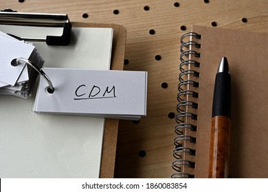 There's a notebook, and a clipboard with a wordbook on it that says CDM.