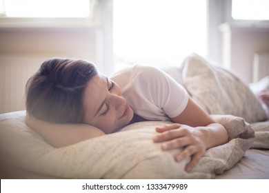 There's nothing better than a lie in. Woman sleeping in bed. - Shutterstock ID 1333479989