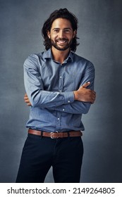 Theres Something Majestic About This Picture. Studio Portrait Of A Handsome Young Man Standing With His Arms Folded Against A Grey Background.