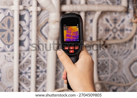 a thermal camera performing an energy performance diagnosis (DPE) of an apartment on the pipes.