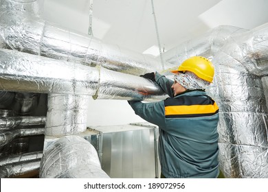 Thermal Insulation. Female Insulation Worker Isolating Industrial Pipe With Glass Wool And Foil