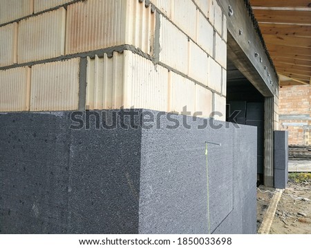Thermal insulation with graphite polystyrene on the house wall at the construction site