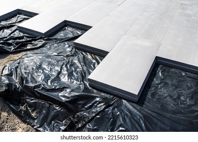 Thermal Insulation Material For Laying The Foundation. Panels From Synthetic Materials On A Polyethylene Film. Floor Waterproofing And Garage Or Home Insulation. Close-up. No People