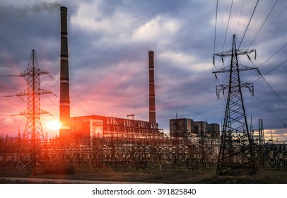 Thermal power plants with huge pipes and power lines at beautiful sunset