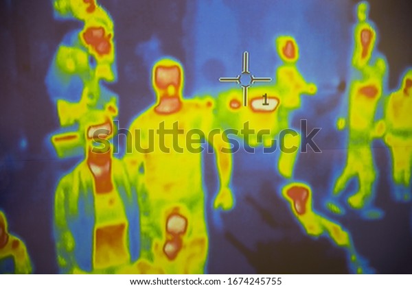 Thermal scanner / camera detecting infected\
people with Covid-19. Group of people under thermal imaging camera.\
Modern airport checking\
system.