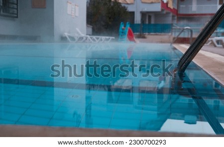 thermal water open air pool, blue water , ladder, steamy view