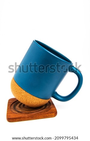  Thermo mug with cork bottom on wooden stand isolated on white background.