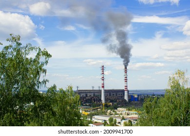 A thermoelectric power station chimneys with black steam smoke against sky.Ukraine, Ukrainka city