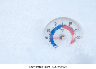 Thermometer with celsius scale placed in a fresh snow showing sub-zero temperature minus 30 degree - extreme cold winter weather concept - Powered by Shutterstock