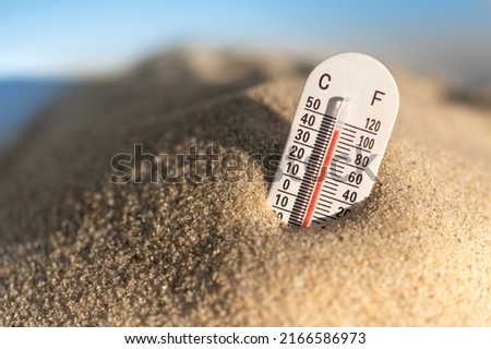 Thermometer displaying hot temperatures in summer day. Both ceclius and fahrenheit.