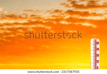 Thermometer with extreme temperature and dramatic clouds. Conceptual image symbolizing a drastic climate changes on our planet
