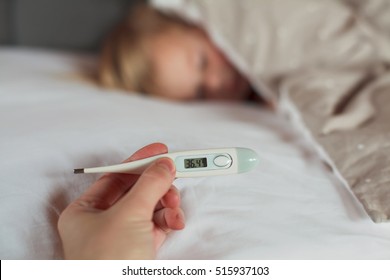 Thermometer In Hand On A Background Slip Child. Normal Temperature.