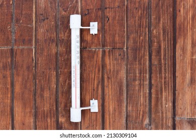 Thermometer hanging on a wooden wall in the street. Temperature 0 degrees on a outdoors thermometer with a Celsius scale