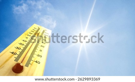 Thermometer with high temperature against the background of clear sky and shining sun. Heat wave concept. extreme weather. global warming effects