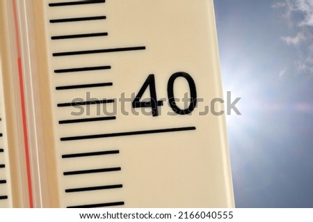 Thermometer indicating 45 degrees centigrade on sunny sky background