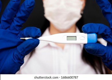 Thermometer for measuring body temperature in the hands of a doctor close-up. Coronavirus epidemic. Symptoms of coronavirus. - Shutterstock ID 1686600787